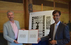 Martin Chaudhuri vom Bundesfinanzministerium übergibt einen Satz der Lotte-Reiniger-Briefmarken an OB Boris Palmer (links).