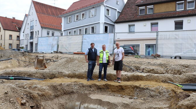 Bürgermeister Andreas Schmidt (von links), Ingenieur Gerhard Lutz und Archäologe Sören Frommer vor der Baugrube auf dem kleinen