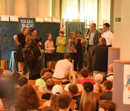 Viertklässler der FES Reutlingen befragen auf der Stadtbibliotheks-Bühne den Reutlinger Oberbürgermeister Thomas Keck (2. von re