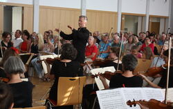 Dirigent Thomas J. Mandl und die Streicher befanden sich im Parkett, die Bläser auf der Bühne der Richard-Wolf-Halle.