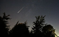 Eine Perseiden-Sternschnuppe leuchtet am Nachthimmel auf.