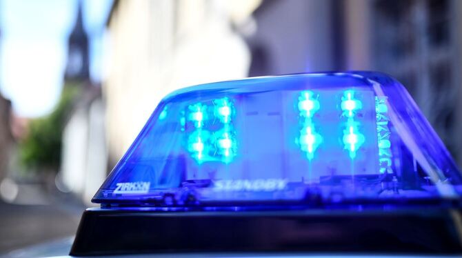Ein Polizeiauto mit blinkendem Blaulicht steht vor einem Gebäude