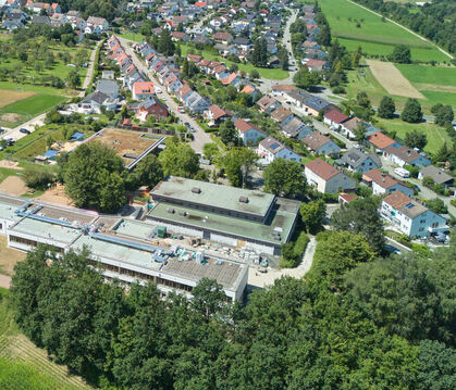 Blick auf das Schulgelände in Sickenhausen von oben: Links im Hintergrund die Containerbauten, länglich im Vordergrund die sanie