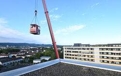 In der Hochhaussiedlung an der Humboldstraße schwebt Kathrin Bindemann im Rollstuhl sitzend in der Rettungskanzel der Höhenrettu