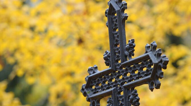 Ein eisernes Kreuz steht auf einem Friedhof