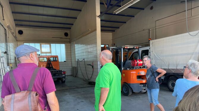 Harry Nonnenmacher (grünes T-Shirt) zeigt Besuchern die Garage im Bauhof. Im Boden sind Wasserdüsen eingebaut, mit denen Winterd