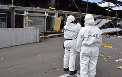 Zwei der Brandermittler vom Polizeipräsidium Reutlingen machen Aufnahmen vom Außerbereich der nahezu vollständig zerstörten Lage