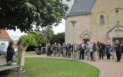 Die ehemalige Pfarrerin Gabriele Brückner stellt den Bibelgarten vor der Wannweiler Kirche vor.