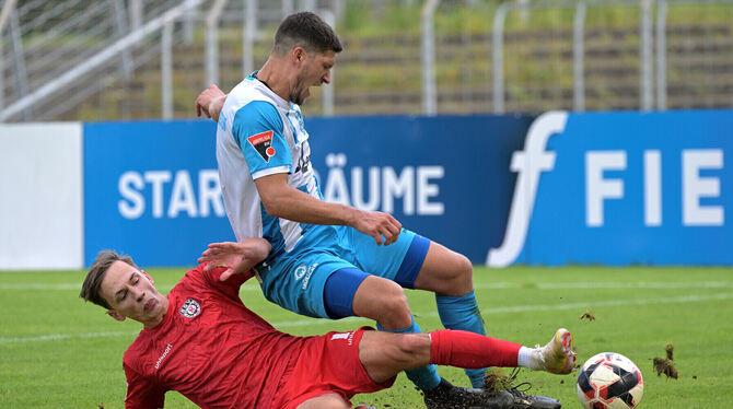 Cedric Guarino (im roten Trikot) vom SSV Reutlingen im Zweikampf mit Oberacherns Angreifer Nico Huber.