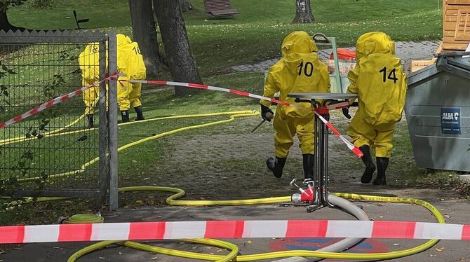 Einsatzkräfte in Schutzmontur auf dem Weg zur möglichen Gefahrenstelle.