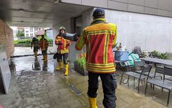 Das Wasser der Echaz kommt bis ans Haus. Die Feuerwehr Pfullingen ist zur Stelle und legt Sandsäcke mittels einer Kette.