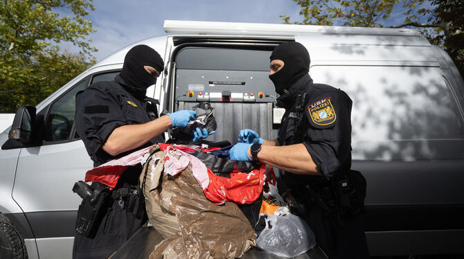 Bayrische Polizisten kontrollieren am Tag der Großrazzia Pakete, die in einem Lastwagen am Stadion Kreuzeiche sichergestellt wur