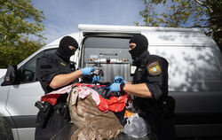 Bayrische Polizisten kontrollieren am Tag der Großrazzia Pakete, die in einem Lastwagen am Stadion Kreuzeiche sichergestellt wur