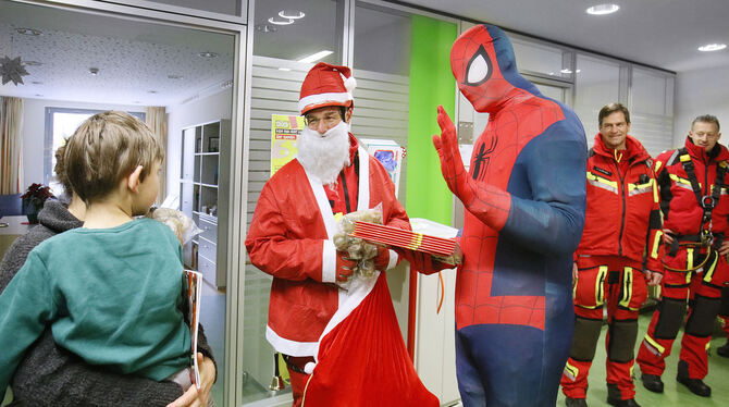 Die als Nikolaus und Spiderman verkleideten Höhenretter der Reutlinger Feuerwehr verteilen in der Kinderstation Teddybären und M