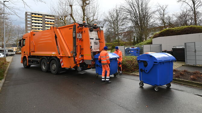 Müllwerker der Technischen Betriebsdienste leeren einen Papiercontainer.