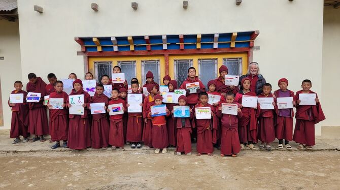 Schülerinnen und Schüler der Klosterschule Taksindu halten Bilder, die sie für ihre Partnerschule in Ravensburg gemalt haben.