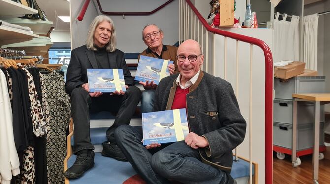 Verleger Wolfgang Wiedemann (links), Autor Reiner Frenz und Segelflug-Ikone Uli Schwenk (vorn) mit dem neuen Buch.   FOTO: SCHRA