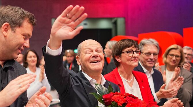 Bundeskanzler Olaf Scholz winkt nach seiner Wahl zum SPD-Kanzlerkandidaten neben Saskia Esken und Lars Klingbeil .  FOTO: KAPPEL