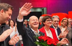 Bundeskanzler Olaf Scholz winkt nach seiner Wahl zum SPD-Kanzlerkandidaten neben Saskia Esken und Lars Klingbeil .  FOTO: KAPPEL