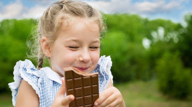 chocolate,eating,girl,little,child,kid,young,holding,nature,happy,sweet,childhood,people,caucasian,happiness,outside,outdoor,cut Ein Mädchen isst eine Tafel Schokolade.