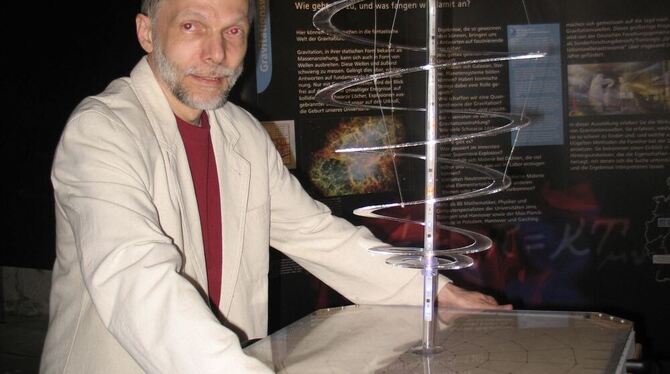 Hans-Peter Nollert an der Plexiglas-Spirale. Hier werden Gravitationswellen simuliert, die dann senkrecht durch ein Tuch laufen.