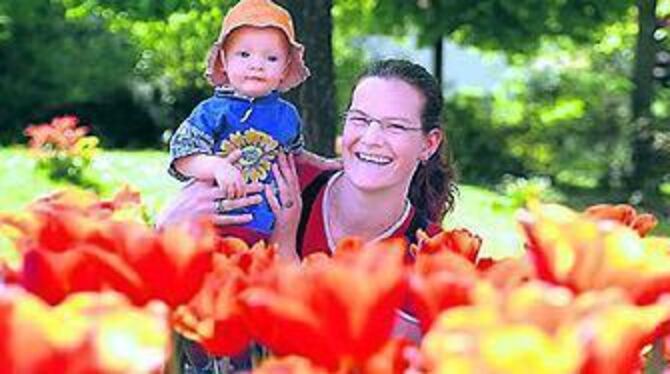 Einfache, späte Tulpen bezaubern durch ihre Schlichtheit. Die Gönningerin Daniela Hettler mit ihrem Töchterchen Luca freut sich, dass die Tradition aufrechterhalten wird. 
FOTO: TRINKHAUS