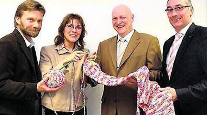 Frisch gestrickt ist halb gespendet: (von links) Udo Stelzer von der Hochschule für Wirtschaft und Technik, Tanja Ulmer, Chefin der Stadtmarketinggesellschaft Reutlingen sowie Peter Voss und Edgar Lehmann von der Werbegemeinschaft RT-Aktiv. 
FOTO: TRINKHAUS