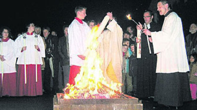 Osterfeuer ökumenisch: Die Pfarrer Matthias Dangel von der katholischen Heilig-Geist-Kirche (rechts) und Stephan Sigloch von der evangelischen Kreuzkirche entzünden ihre Osterkerzen an einem Feuer an der Ecke von Mozart- und Paul-Pfizer-Straße.
FOTO: SCHINDLER