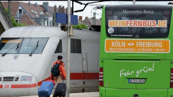 Konkurrenz für die Bahn: Ein Fernbus steht am Bahnhof in Freiburg neben einem ICE. Foto: Patrick Seeger/Archiv