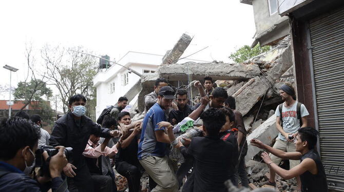 In den Trümmern von Kathmandu bergen Helfer ein Erdbebenopfer.