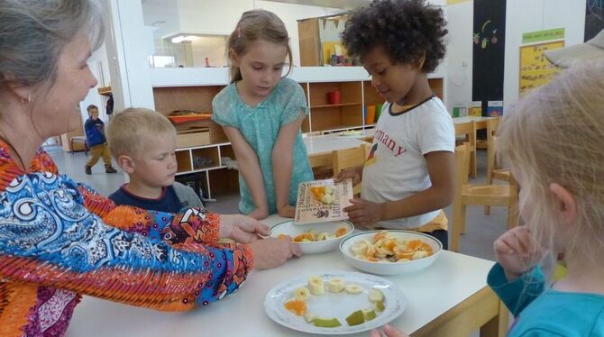 Im Wankheimer Kinderhaus bringt Steve geschnittenen Obst-Nachschub, den die Kinder auf Tellern dekorativ anrichten.  FOTO: WEBER