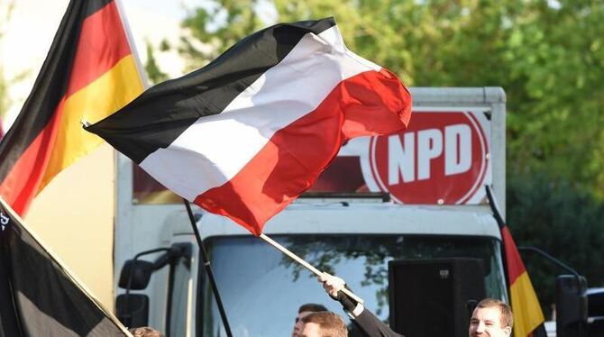 Teilnehmer an einer Kundgebung der NPD winken in Berlin mit ihren Fahnen. Foto: Jens Kalaene