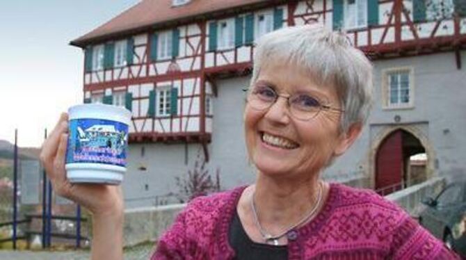 Das Vorbild und das Abbild: Edith Kosellek mit ihrer Weihnachtsmarkt-Tasse vor dem Gomaringer Schloss. FOTO: TRINKHAUS