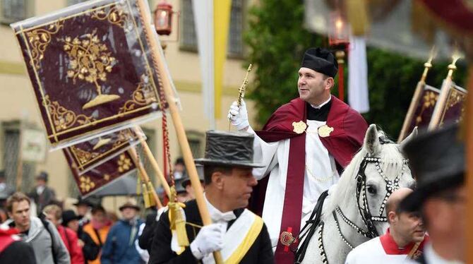 Dekan Ekkehard Schmid, der Heilig-Blut-Reiter, hält in Weingarten beim traditionellen Blutritt auf einem Schimmel die Heilig-Blu