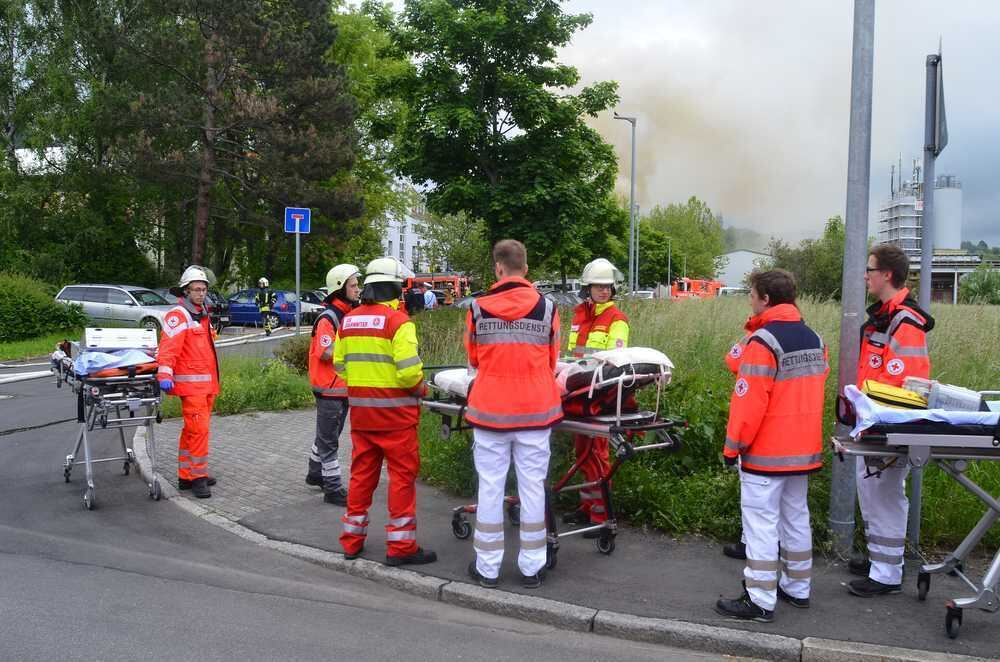 Sanitäter stehen in gebührender Entfernung vom Brandort.