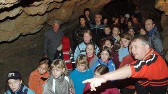 Erdkunde in 14 Metern Tiefe: Frank Schüler (rechts) und Ernst Etter (links) erklären Pfullinger Schülern die Olgahöhle. GEA-FOTO