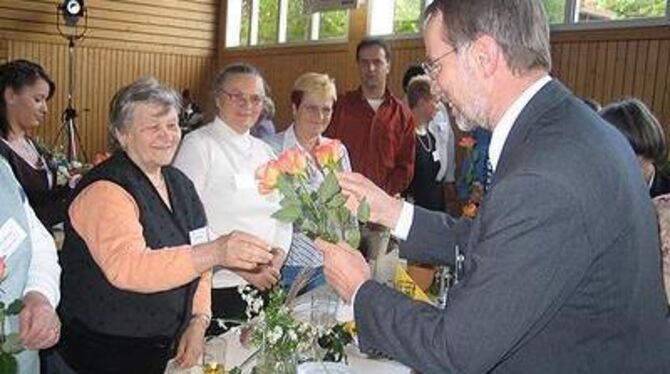 Dekan Ulrich Poguntke beschenkt die Helferinnen und Helfer mit Rosen. FOTO: TIA