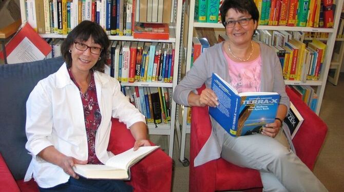 Ulla Krämer und Gabi Betz, rechts, sind gespannt auf Fotos, die zeigen, welche Bücher im Urlaub gelesen werden. GEA-FOTO: OELKUC