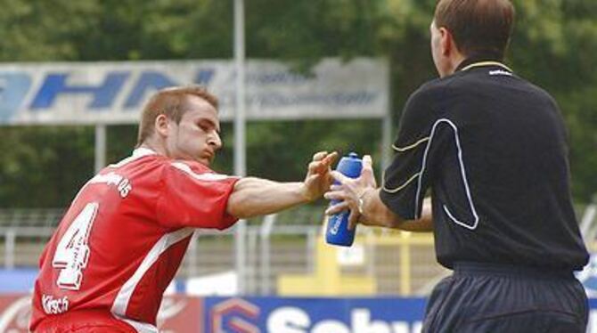 Ein Schluck aus der Pulle: Patrick Kirsch (links) lässt sich von Trainer Peter Starzmann bedienen.  FOTO: NIETHAMMER