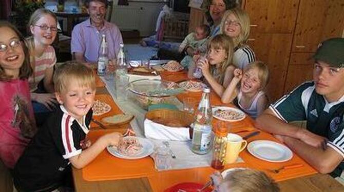 Am großen Familientisch in der Küche fühlen sich die neun Kinder der Renners mit Vater und Mutter wohl. GEA.FOTO: OELKUCH