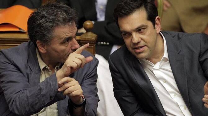 Der griechische Finanzminister Tsakalotos (l) spricht im Parlament in Athen mit Ministerpräsident Tsipras. Foto: Orestis Pana