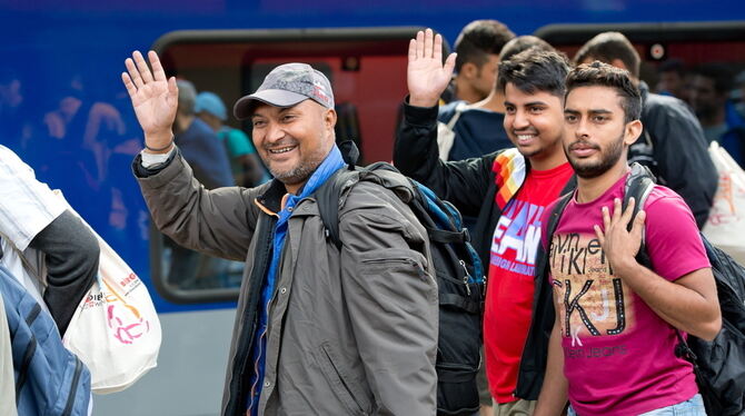 Flüchtlinge, die kurz zuvor mit einem Zug aus Salzburg angekommen sind, laufen auf dem Hauptbahnhof in München (Bayern) über ein