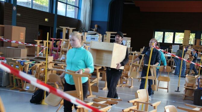 Aus dem nach Klassenzimmern aufgeteilten Zwischenlager in der Gemeindehalle zogen die freiwilligen Helfer die Schulmöbel aus Lon