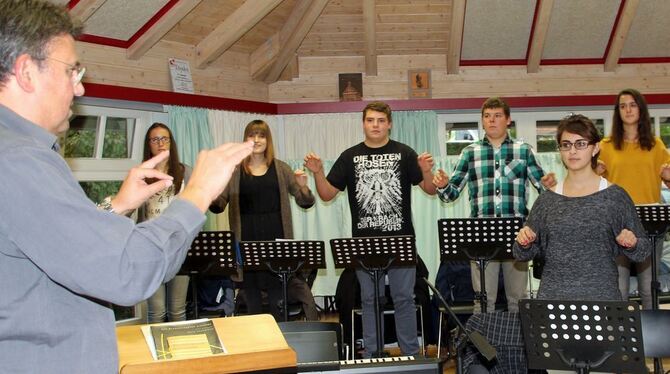 So agiert ein guter Dirigent: Thomas Wunder (links) macht es beim Workshop in Eningen vor. FOTO: LEIPPERT