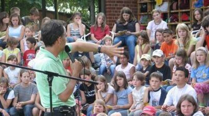 Gebannt folgen die Kinder der Geschichte von Abraham: Stadtranderholung mit Diakon Günter Weber. GEA-FOTO: MMO