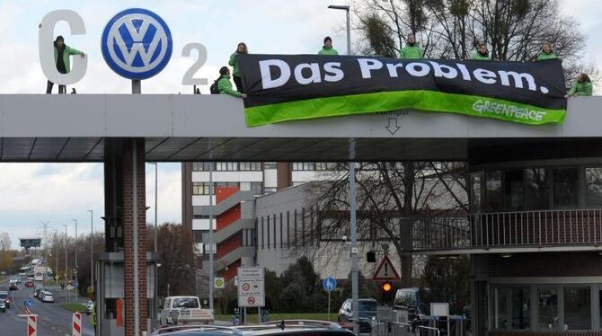 Greenpeace-Aktivisten stehen mit einem CO2 Banner über dem Werkstor von Volkswagen in Wolfsburg . Foto: Peter Steffen