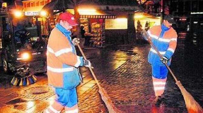 Vorarbeiter für Kehrmaschinenfahrer Klaus Bader: Kurt Czegley (rechts) und Wolfgang Laemchen beim Fegen des Marktplatzes. FOTO: