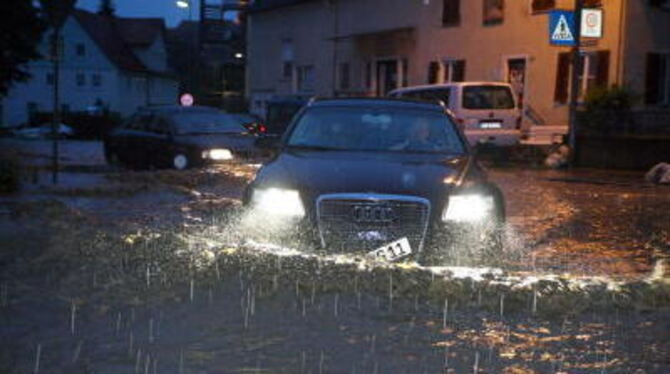 Ein Autofahrer bahnt sich am 2. Juni nachts einen Weg durch eine überflutete Straße in der Hechinger Unterstadt. Dort toben heft