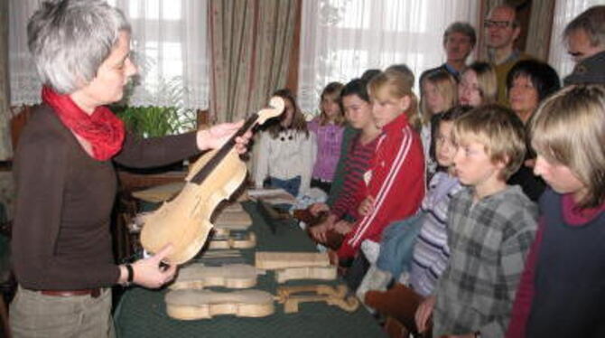 Almnut Schubert zeigt den jungen Musikern vom Münsinger Gymi, wie aus dem Holz des Bergahorns Geigen entstehen. GEA-FOTO: GEIGER