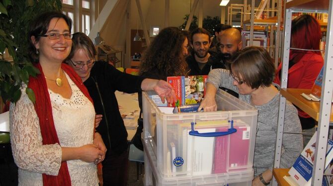 Die Stadtbücherei und die Sprachlehrerin zeigen den Flüchtlingen das interkulturelle Medienangebot in Betzingen.  FOTO: KAPPEL